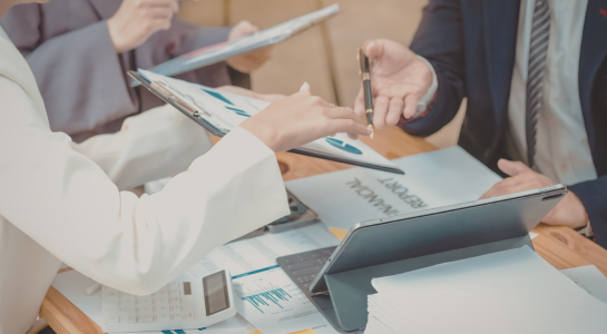Colleagues reviewing financial documents and charts during a business discussion.