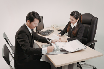 Business professionals reviewing documents together at an office desk.